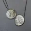 Placeholder: pendant in a form of two conjoined silver coins, watercolor, large strokes, illustration, fantasy