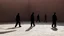 Placeholder: Detail of the prison courtyard: shadowy figures marching in a textured brick environment.