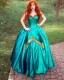 Placeholder: Magic princess with long auburn hair in a big teal green and gold satin ballgown corset off shoulder top casting magic