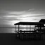 Placeholder: Terraza de un chiringuito frente a la playa al atardecer, fotografía realizada con una cámara Leica y con un objetivo de 50 mm, fotografía real, fotografía en blanco y negro