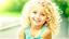 Placeholder: A cute little girl, curly blonde hair, the look on her smiling face.