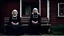 Placeholder: gloomy-looking old women sitting in black hungarian villager dress and wearing east european black head scharf on wooden bench in front of white old house outside in an authentic east european ,hungarian village, high detalied, professional photo, high qualit, high textures. The high-resolution image captures the essence of authenticity and realism, transporting the viewer to another time and place.