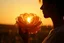 Placeholder: A panoramic mixed-media scene in a 3:1 format, with a silhouetted woman holding a large lace flower glowing in the golden light of sunset. The flower, made of layered cream and blush doilies, catches the warm rays