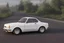 Placeholder: a white Alfa Romeo 75 car drifting on a country road in a sunset day of summer