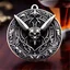 Placeholder: metal jewelry symbol, ancient, magic,on dark wooden table with drinking glass