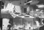 Placeholder: black and white storyboard, Peaple on foreground, between them in the middle we see cooks, scattered throughout the kitchen