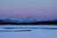 Placeholder: Night, Moon, distant mountains, pine trees, lagoon, lagoon reflections, winter, ice, snowy land