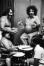 Placeholder: Frank zappa playing bongos next to a very fat black man