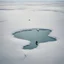 Placeholder: A captivating hyper minimalist photograph from a helicopter of a barren snow-covered lake, in the far distance is a man sitting in a chair ice fishing. The overall color palette is muted, the flat treeless landscape stretches out in a long shot, creating a sense of isolation and desolation