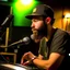 Placeholder: A short brown beard, DJ board,man with a baseball hat sing at microphone, on danchall , microphones,, laser lights, FRONT VIEW