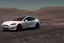 Placeholder: A Tesla 'Model S' is racing at top speed, at the lunar landing site of the 'Apollo 11'. (CINEMATIC, WIDE ANGLE LENS, PHOTO REAL)