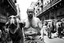 Placeholder: man looking like "Walter White" in breaking bad tv show, bald and goatee glasses, with bare chest riding on a camel in a alley Casablanca town, panorama, black and white photo, lot of markets and people in background