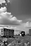 Placeholder: landscape ,Photo with an old analog camera. Black and white. Part of a strange dream. white clouds wide plain The big building between them. like pink floyd pigs land scape from a weird dream captured with the first model of dreamrecorder by gnom industries inc