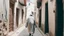 Placeholder: Rear view of an elderly Moroccan walking in a Moroccan alley with white walls