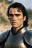 Placeholder: A portrait of Joaquin Phoenix from year 2000, beachy haircut, black hair, in medieval setting, in burnished medieval samurai armor, melancholic and dangerous facial expression