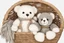 Placeholder: Cute but quirky stuffed animals lie in a carved basket on a soft sling, by candlelight