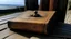 Placeholder: 1 singular Book lying with a cover on table the cover depicting a woman on the beach, medieval grimoire, no people, no cluter