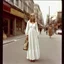 Placeholder: 1910, old Autochrome photo with black frame, Young Singer Michelle Phillips , in the street; long white hippie dress,