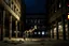 Placeholder: giraffe in the middle of a large central courtyard between decaying buildings, midnight, giraffe illuminated by dim light, reality, real photography, 16K, like in the movie 'The Great Beauty' by Sorrentino