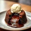 Placeholder: A decadent Molten Lava Cake, oozing with hot molten chocolate from its cracked center, elegantly presented on a plate with a dollop of creamy ice cream perched on top. This sumptuous dessert is depicted in a photograph, capturing the richness of its textures and colors. The luscious chocolate appears almost liquid, while the cake's exterior glistens with a hint of golden crust. The ice cream melts slightly, creating a tantalizing contrast of temperatures. The image exudes a sense of indulgence a