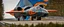 Placeholder: A national geographic award winning photograph of a military fighter jet station wagon elephant hybrid bilaterally symetrical designed by skunkworks, only one vehicle per image painted metallic orange traveling at a high rate of speed, jet intake off of front center of vehicle and jet exhaust out the rear with bright blue flame soviet retrofuturism, taken from drivers side front at a angle from up and to the rear