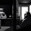 Placeholder: comicbook, 2 panels, black and white, in the left panel, a fat, bearded man watches the tv, (in the right panel, (side angle view:1.2)of the tv), background is a haunting dimly lit, decrepit room.The atmosphere should be chilling, with shadows and decay adding to the eerie ambiance.