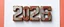 Placeholder: "2026" in squared block letters made of shiny and rusty metal on contrasting background