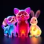 Placeholder: Three colored translucent 3D animals — a small dog, a cat, and a rabbit — standing together in funny poses, each made of glowing glass-like material with vibrant iridescent gradients of cyan, magenta, amber, and violet glowing from within. Subsurface scattering, refractions, and caustics pass light through their transparent bodies, revealing soft inner structures. Cute proportions with rounded forms, floating in a dark void, volumetric lighting, octane render, hyperrealistic, ultra-detailed, 8k,