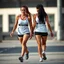 Placeholder: Two female athletes wearing shorts and walkng.