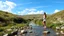 Placeholder: country side small river nice rocks at floor wild flowers blosom pretty sky and cloudes a beautiful young lady standing gracefully in water