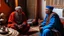 Placeholder: Two fifty-year-old people in traditional Moroccan clothing are discussing in the room of a Moroccan house