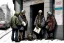 Placeholder: A group mature homeless street cats cats cats with worn out clothes, standing in a corner on the street, holding wine bottles in their wings , Vienna, mourning, model style, hyper realistic, extremely accurate, delicate, extremely detailed, Graphic novel style, wide-angle, open aperture, superfine pencil