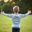 Placeholder: 12 year old boy from behind with arms outstretched