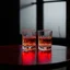 Placeholder: a table showing two whisky glasses in a dark room, red neon hues