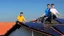 Placeholder: solar panel installation by 2 - 3 guys on the roof of a house, panoramic view