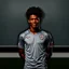 Placeholder: 85mm DSLR color photography of a very detailed headshot fitting all of head and hair in frame. 20-year-old American soccer player, with black hair color and with small facial hair and has a brown skin tone and has a small afro and a taper fade with a small smile, grey background