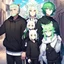 Placeholder: In anime, an anthropomorphic male character with white fur, white-and-green-haired, white-skinned, green-eyed, wolf ears, whiskers, a black hoodie, and black pants, is on the street in the massive capital.