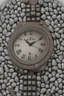 Placeholder: Silver wristwatch studded with precious stones containing the word jiks