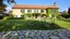 Placeholder: big beautiful country side villa with a large garden and grass and flowers in front and stone pavements