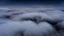 Placeholder: looking down from space at the mist and clouds, surrounded by the mist at night starry sky. majority of the image is space, only the bottom third of the image is clouds