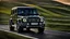 Placeholder: A sleek ((( Mercedes-AMG G 63 BMW))) with a majesticly curved rear, cutting through a (sunny, open countryside) backdrop