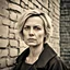 Placeholder: sweet woman, 35 years old, with blond short hair, facial skin with very noticeable unevenness and pores, face with wrinkles and unevenness, two nasolabial wrinkles on the face, wrinkles near the eyes, bags under the eyes, standing against an old brick wall on the street, during the day, abstract neorealism, cinematic, hyper-detailed, hyper-realistic, masterpiece, atmospheric, fashion photography, HDR, Polaroid film