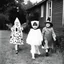 Placeholder: Kids(in spooky costumes)trick or treating on Halloween. 1960s era