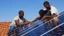 Placeholder: solar panel installation by 2 - 3 black guys on the roof of a house, panoramic view