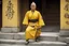 Placeholder: [very impressive high res masterpiece in Kodak Eastman 5247, bokeh scene by Stanley Kubrick] woman Shaolin gangsta monk covered by tattoos waiting outside in yellow kimono, on a stone doorstep, she menaces the camera with her finger