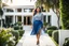 Placeholder: fullbody shot,of beautiful lady walking in a pretty villa garden wearing blue skirt and gray blouse , curvy hair,