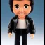 Placeholder: wide view young Plastic Fonzie with black hair greaser toy Action figure doll 1975 (thumbs-up) (face) Forehead grin, fonzarelli, jukebox background, eyes fonzi fonz