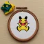 Placeholder: exquisite whimsical pikachu in embroidery hoop, intricate, highly detailed, linen and wood backdrop