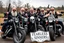 Placeholder: a very hard and tuff motorcycle bald gang, posing with their Harley Davidsson bikes, some of them holding guns and shotguns, a logo sign with Falköpings HD Club, "Fearless sinners" Skulls and bones, skeletons