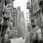 Placeholder: there is a black and white photo of a building with a sign on it, 4x5 styled street photography, kowloon cyberpunk, kowloon walled city style, streets of hong kong, location ( favela ), monochrome lomography, kowloon